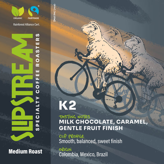 K2.  Illustration of a sheep cycling uphill, facing left, in a playful, cartoon style.